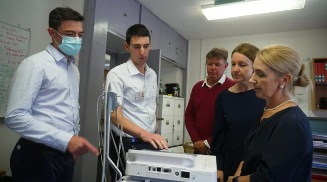 Image showing The TeleECG project team looking at an ECG machine.