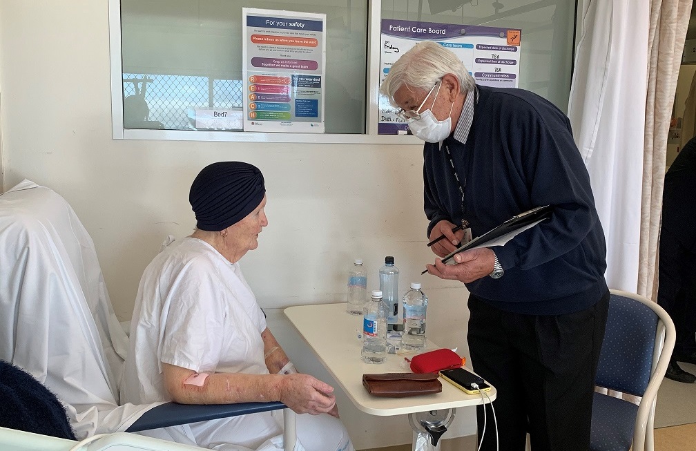 Photo of consumer Bill rounding with a patient